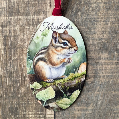 Decorative ornament with a chipmunk illustration and 'Muskoka' text on a wooden background