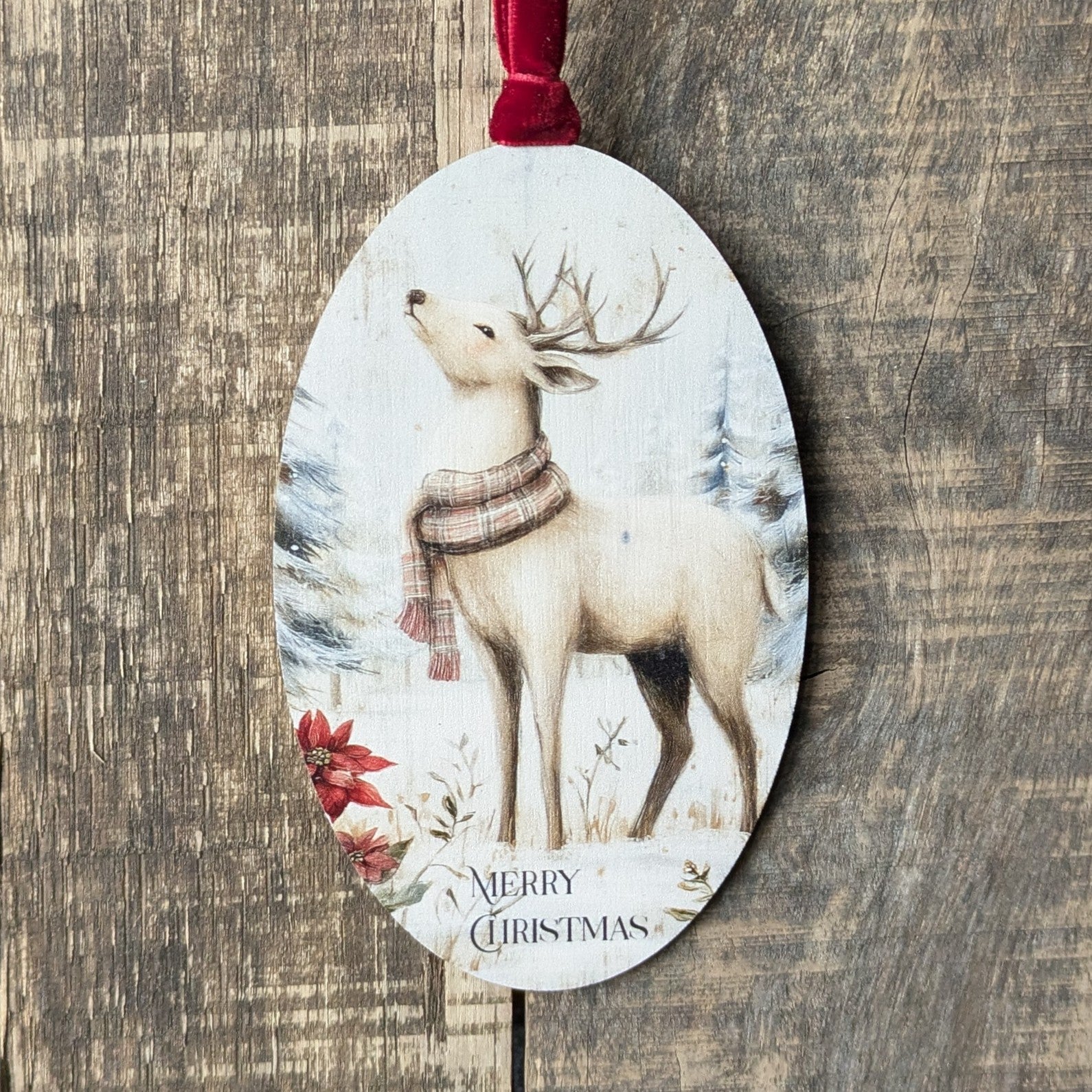 Decorative Christmas ornament with a deer wearing a scarf on a wooden surface
