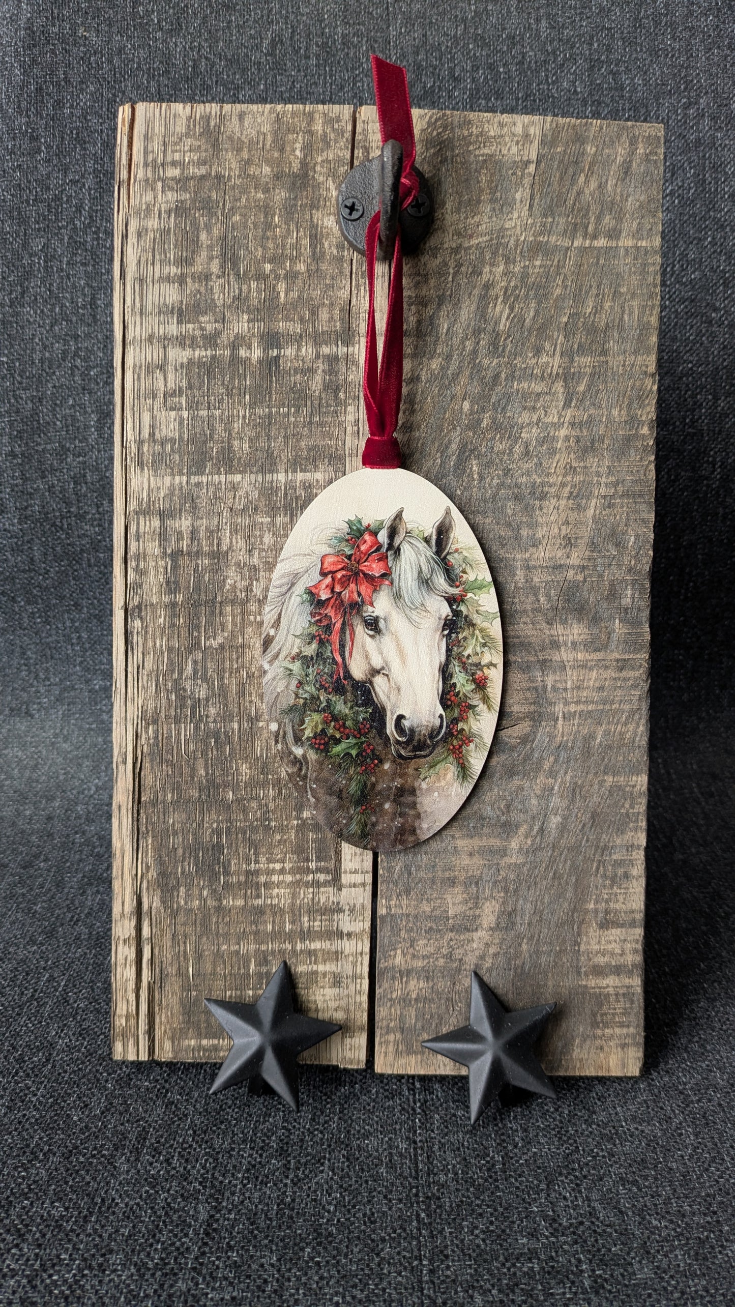 Decorative horse ornament with wreath on a wooden board with stars below