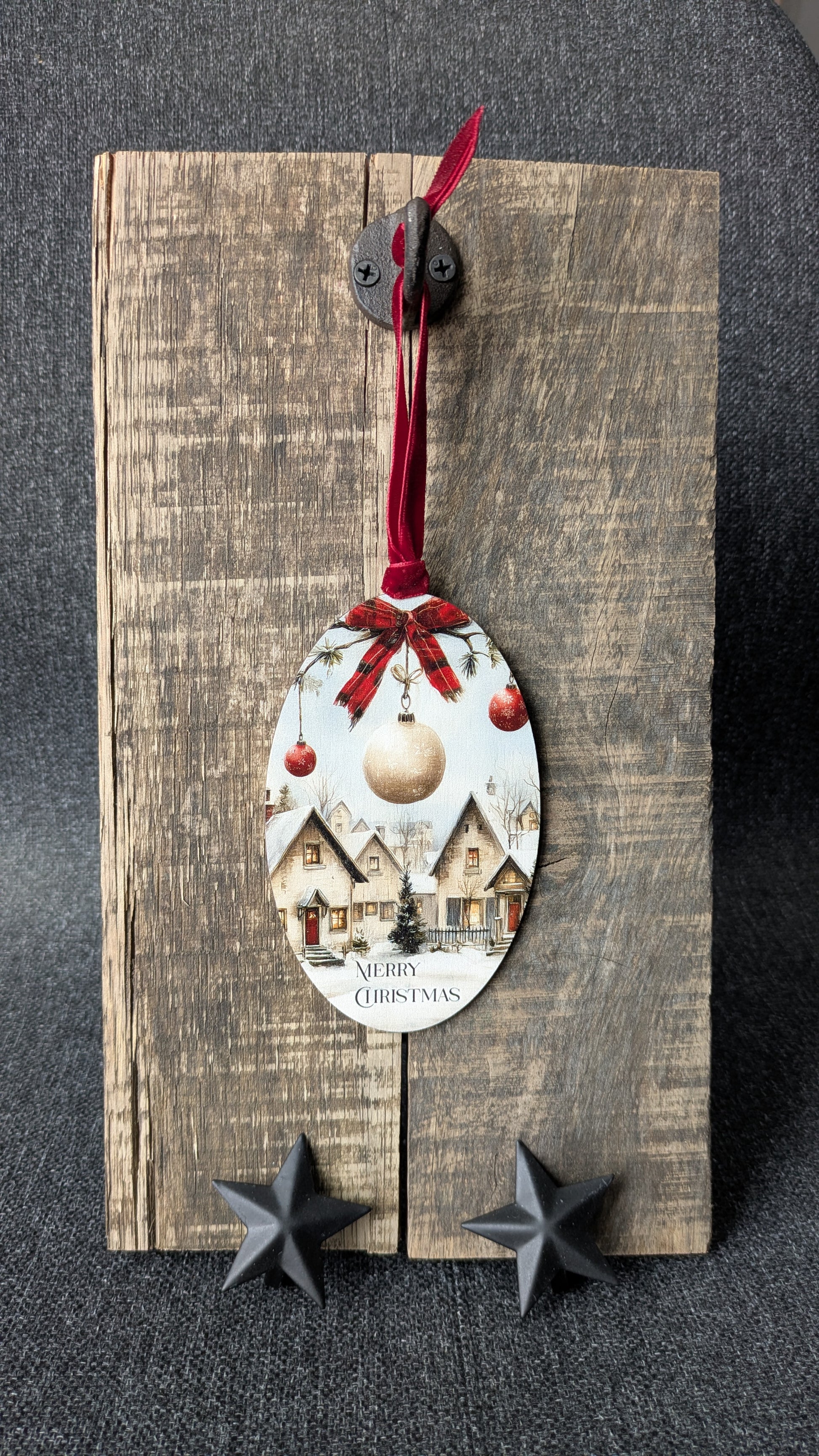 Decorative spoon ornament with Christmas design on a wooden board.