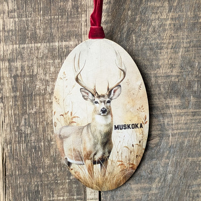 Decorative ornament with a deer design and 'Muskoka' text on a wooden background