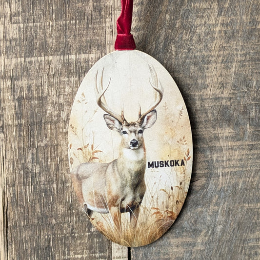 Decorative ornament with a deer design and 'Muskoka' text on a wooden background