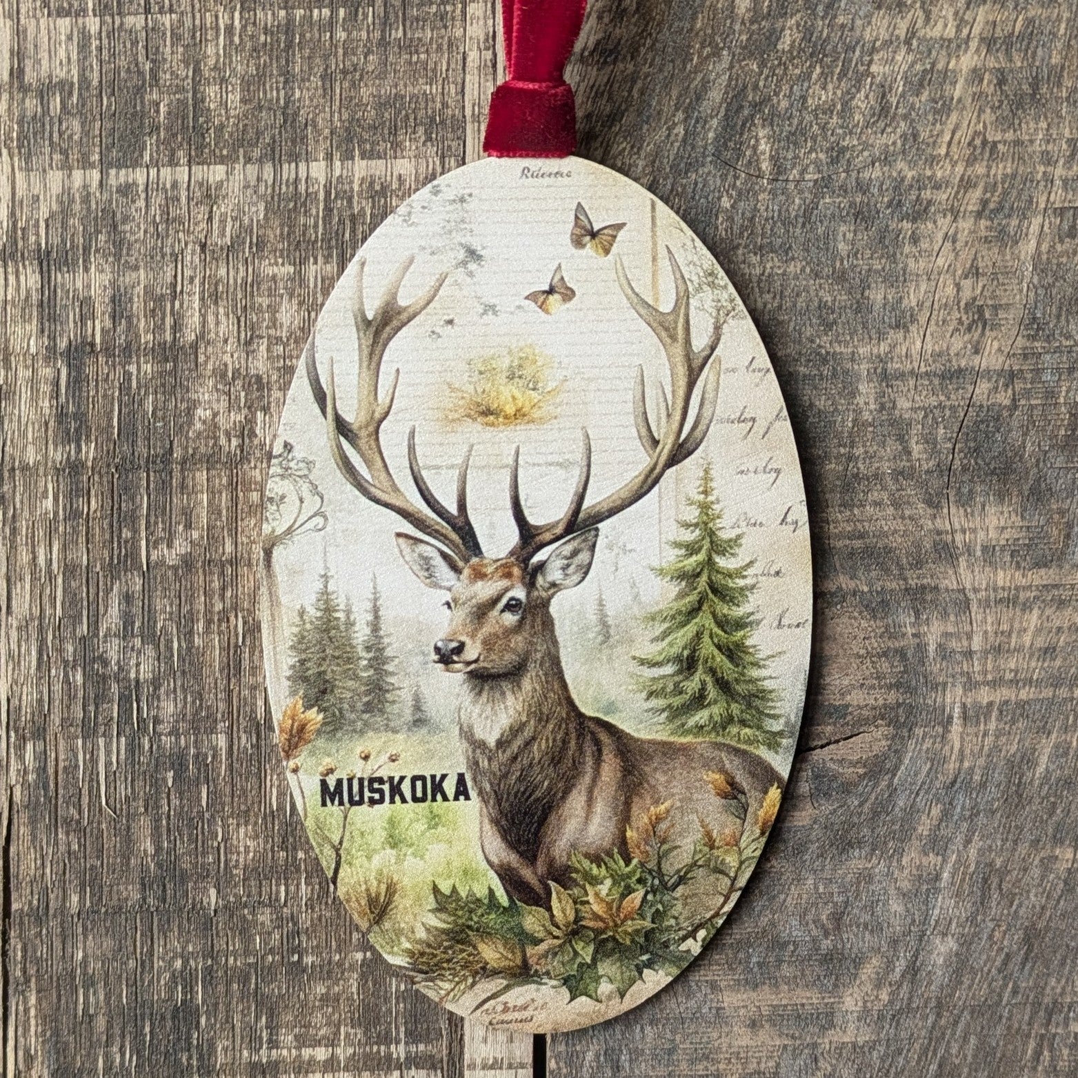Decorative ornament with a deer design and 'Muskoka' text on a wooden background