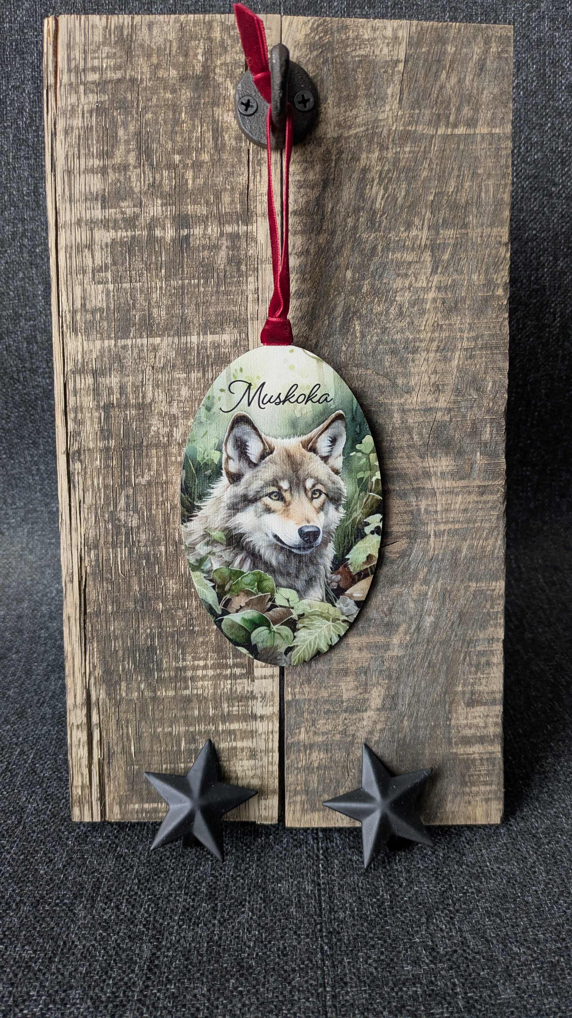 Decorative wooden ornament with a wolf illustration and 'Musikka' text on a dark background