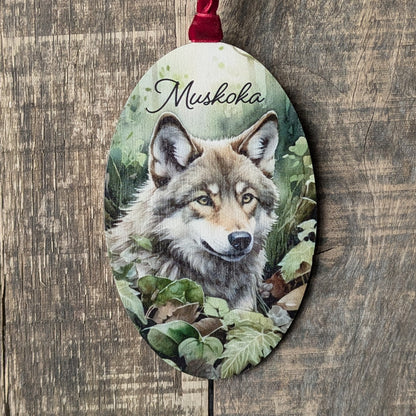 Decorative ornament with a wolf illustration and 'Mushkoka' text on a wooden background