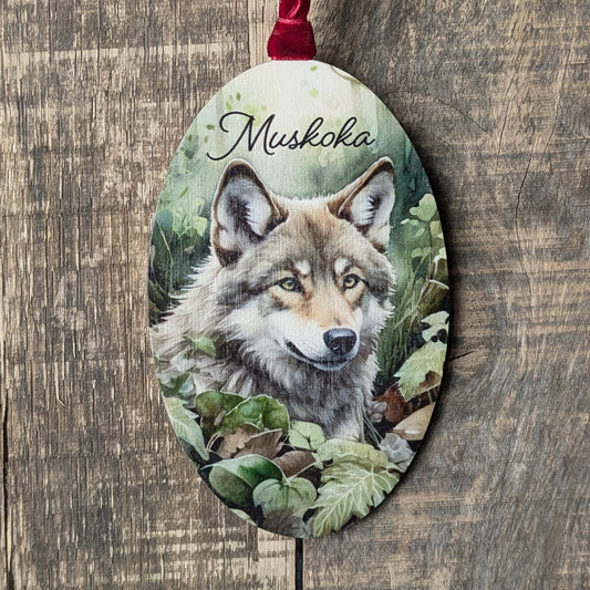 Decorative ornament with a wolf illustration and 'Mushkoka' text on a wooden background
