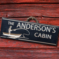 a wooden cabin sign carved and painted in black